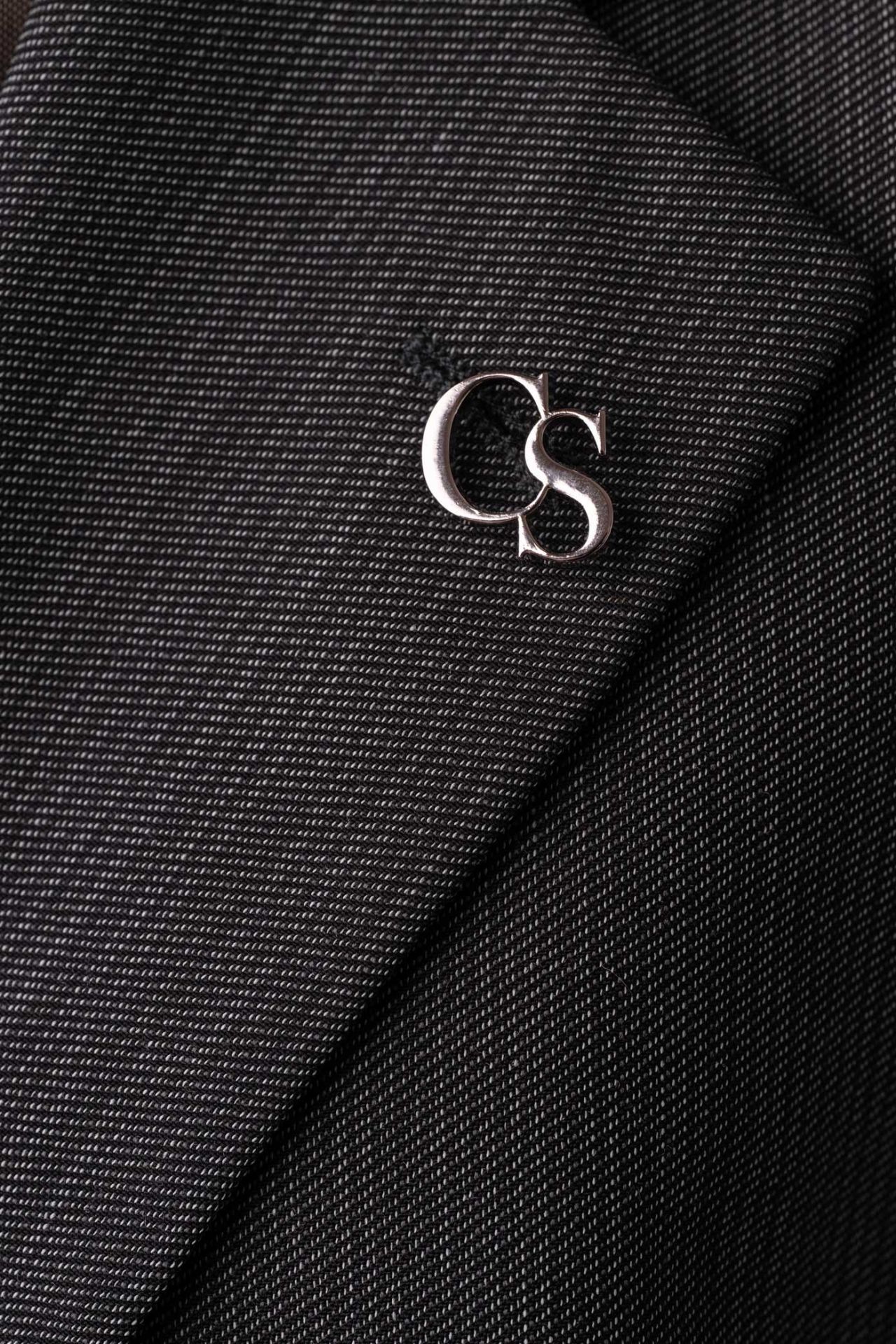 Silbernes CS-Logo als Pin am Revers des Upcycled Bomber-Blazers